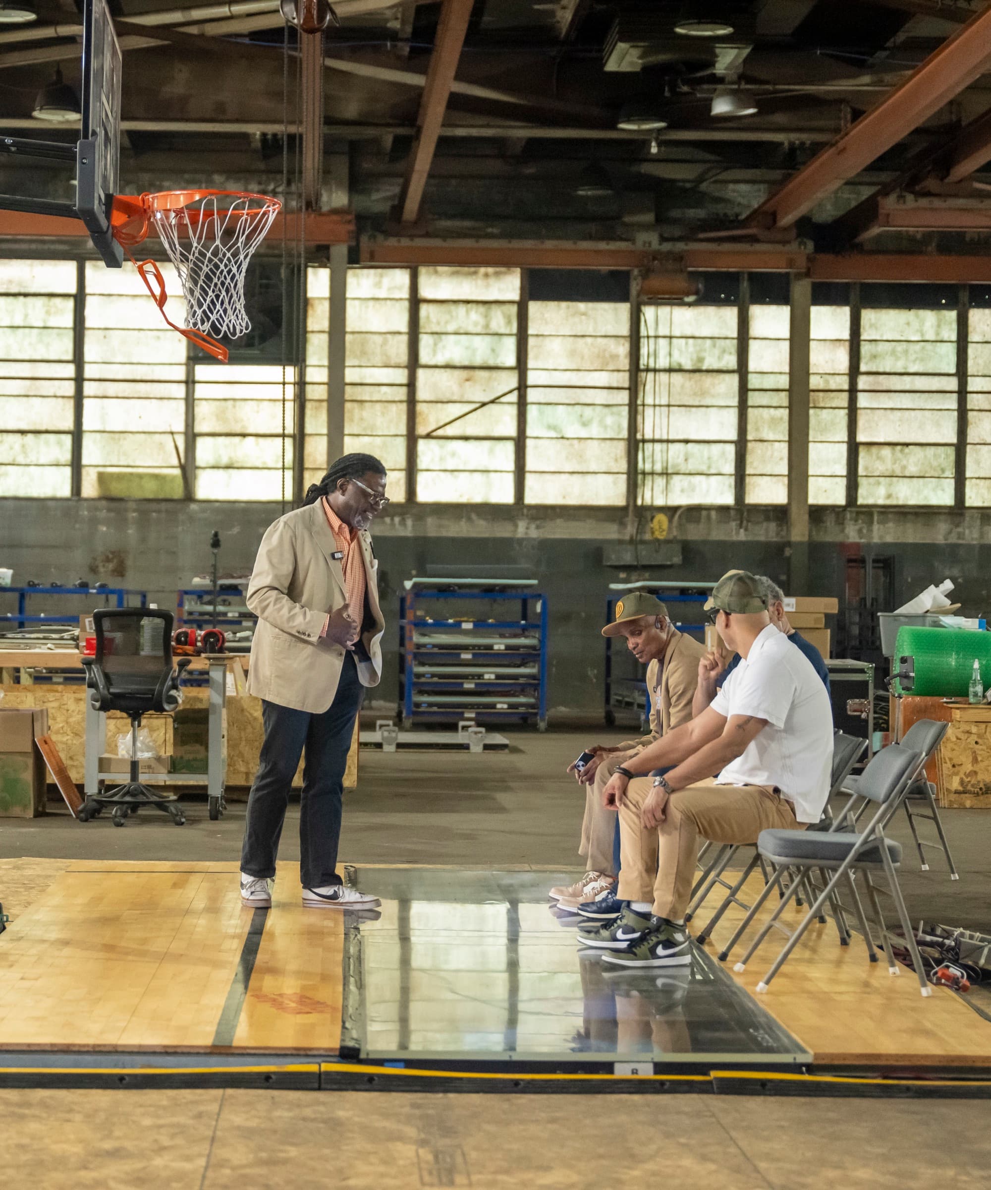 Visitors seated courtside watch a Gen4 panel run inside a hardwood floor at the Courtside facility.